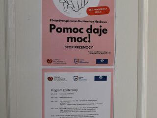 Plakat konferencji „Pomoc daje moc! Stop przemocy” z programem, umieszczony na drzwiach.