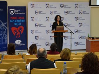 Publiczność słucha prelegentki w auli podczas konferencji OPS.