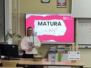 Prowadząca w jasnej bluzie stoi przy ekranie z tytułem „Matura i co dalej?”.