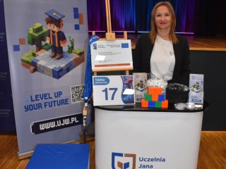 Przedstawicielka uczelni stoi za stoiskiem UJW oznaczonym numerem 17.