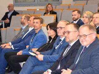 Uczestnicy konferencji o społecznościach lokalnych siedzą w rzędach sali wykładowej.