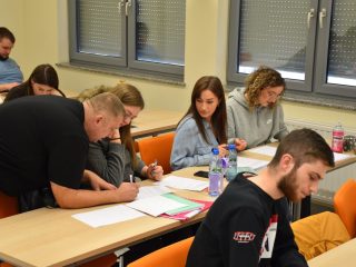 Uczestnik zapisuje odpowiedzi na arkuszu podczas pracy zespołowej nad CV.