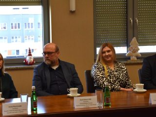 Czworo uczestników Rady Dyrektorów podczas rozmowy przy stole konferencyjnym.