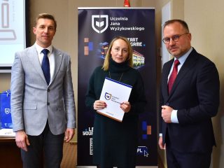 Kobieta w ciemnozielonej sukience prezentuje dokument podczas spotkania Rady Dyrektorów.