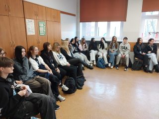 Uczestnicy Chłopskiej Szkoły Biznesu siedzą w kręgu w sali lekcyjnej.