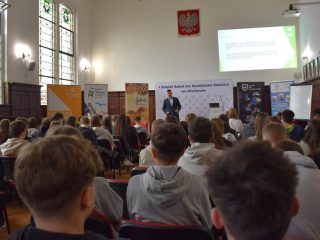 Uczniowie oglądają prezentację podczas Dnia Logistyka w szkolnej auli.