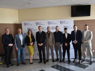 Absolwenci i przedstawiciele uczelni pozują wspólnie przy ściance UJW podczas obron inżynierskich.