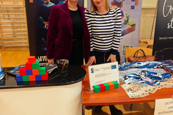 Dwie przedstawicielki uczelni przy stoisku UJW z materiałami informacyjnymi i klockami.