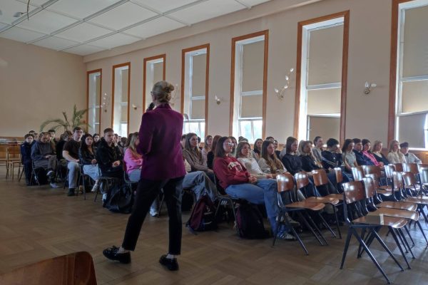 Przedstawicielka UJW rozmawia z uczniami zgromadzonymi w auli.