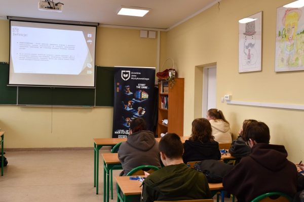 Uczniowie obserwują prezentację wyświetloną w klasie podczas spotkania z UJW.