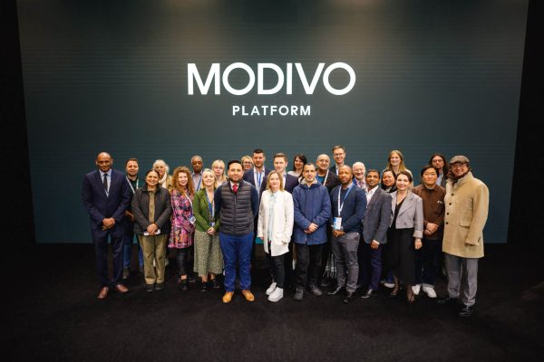 Grupa uczestników konferencji pozuje pod napisem MODIVO Platform.