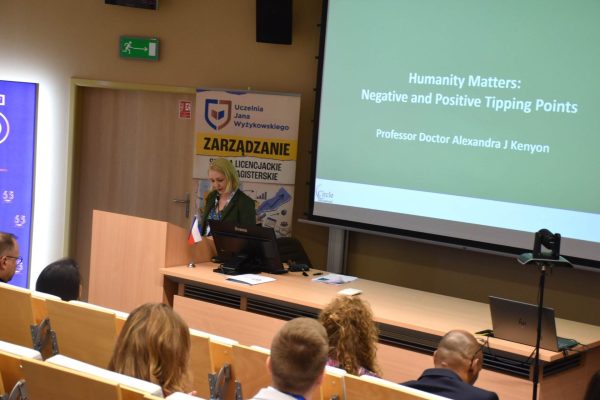 Prowadząca przy mównicy pod slajdem „Humanity Matters: Negative and Positive Tipping Points”.