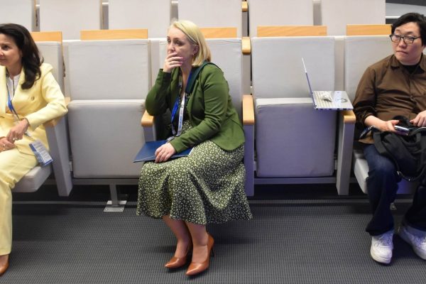 Trzy uczestniczki konferencji siedzą w rzędzie foteli.