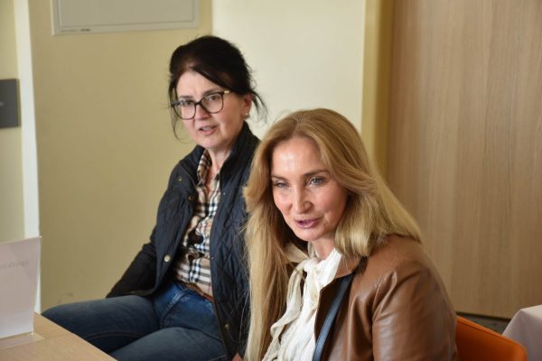 Dwie uczestniczki spotkania Klubu Absolwenta siedzą obok siebie.