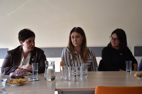 Trzy uczestniczki spotkania założycielskiego siedzą za stołem.