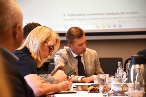 Uczestnicy przeglądają dokumenty podczas posiedzenia Rady Dyrektorów.