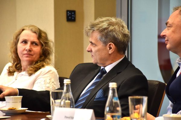 Uczestnicy Rady Dyrektorów rozmawiają przy stole konferencyjnym.