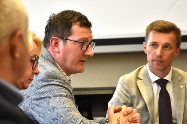 Dwaj uczestnicy dyskutują przy dokumentach podczas posiedzenia.