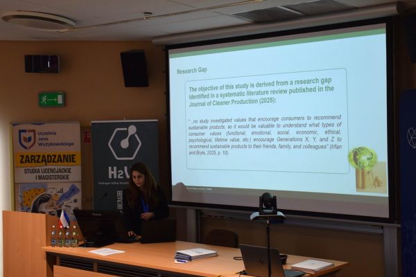 Prelegentka przedstawia lukę badawczą na ekranie konferencji.
