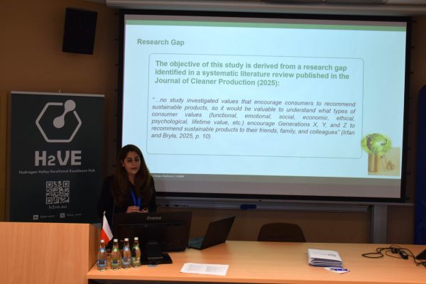 Prelegentka przy mównicy omawia slajd „Research Gap”.