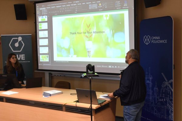 Rozmowa uczestnika z prelegentką pod ekranem zakończonej prezentacji.