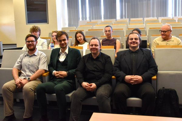 Grupa uczestników konferencji studenckiej pozuje na widowni.