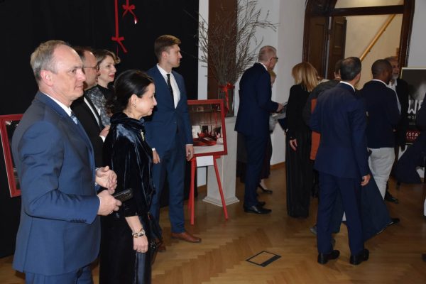 Goście uroczystej kolacji witają się przy wejściu do sali.
