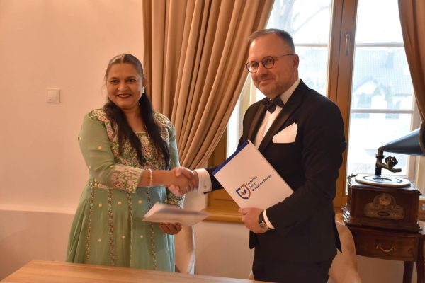 Uścisk dłoni i prezentacja dokumentów porozumienia UJW z uniwersytetem w Indiach.