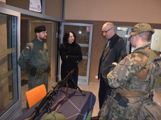 Rozmowa zwiedzających z osobami w mundurach przy ekspozycji broni podczas Dnia Drzwi Otwartych.