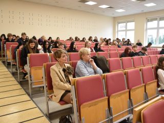 Publiczność zajmująca rzędy krzeseł w auli podczas Dnia Drzwi Otwartych.
