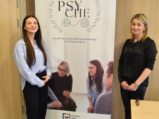 Dwie kobiety po bokach roll-upu koła naukowego PSYCHE.