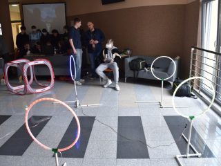 Tor dla małych dronów z okrągłymi bramkami i uczestnikami w tle.
