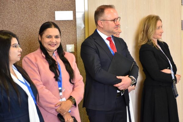 Uczestnicy konferencji z identyfikatorami obserwują występ w holu UJW.