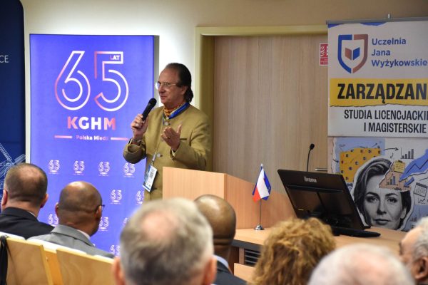 Prelegent gestykuluje z mikrofonem przy mównicy podczas konferencji CIRCLE.