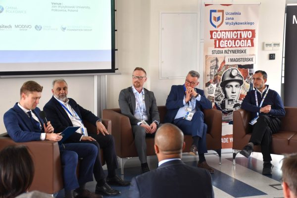 Pięciu panelistów siedzi pod ekranem konferencji CIRCLE przed publicznością.