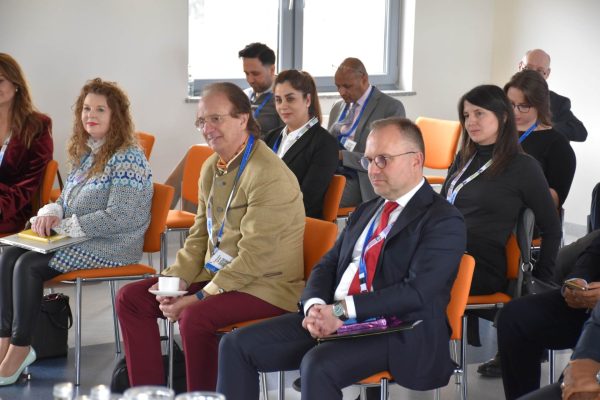Uczestnicy panelu wśród publiczności słuchają dyskusji, część trzyma filiżanki.