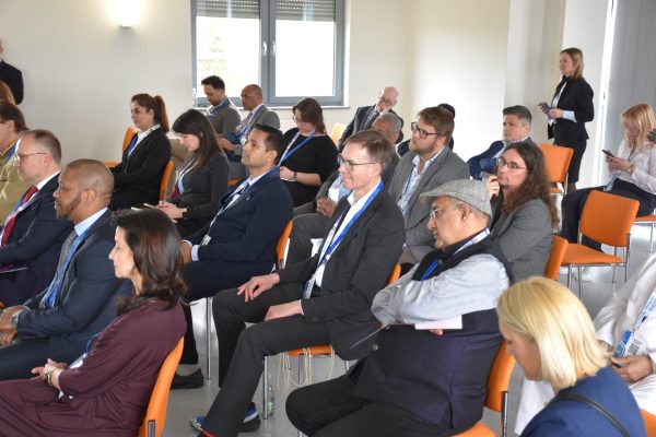 Rzędy uczestników konferencji obserwujących panel dyskusyjny.