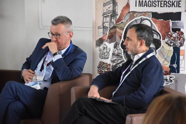 Dwaj paneliści słuchają dyskusji w fotelach na tle planszy kierunku górnictwo i geologia.
