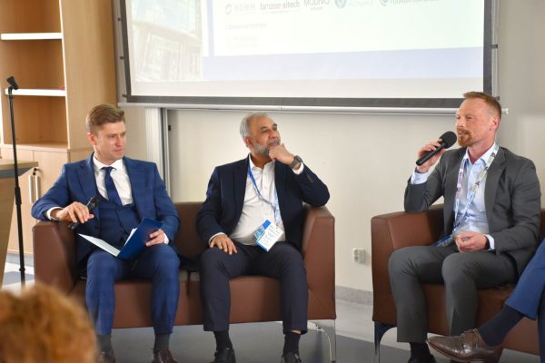 Moderator i paneliści słuchają wypowiedzi mężczyzny siedzącego po prawej.