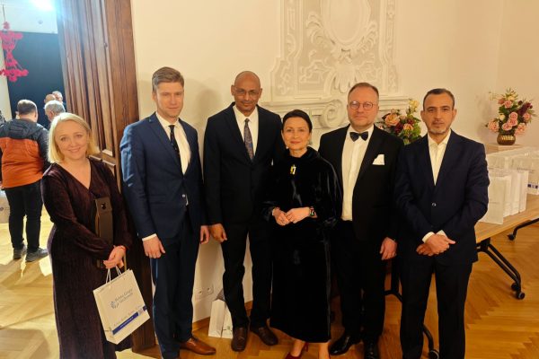 Sześcioro gości pozuje w eleganckiej sali podczas gali.