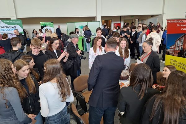 Tłum odwiedzających i wystawców podczas targów edukacyjnych.