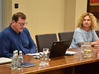 Mężczyzna przy laptopie i kobieta w jasnej bluzce podczas posiedzenia Senatu UJW.