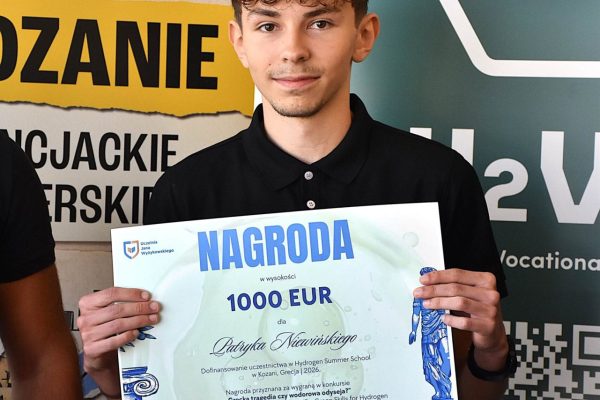 Laureat konkursu trzyma dyplom nagrody w wysokości 1000 euro.