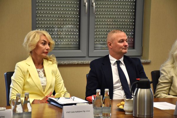 Dwoje uczestników Konwentu słucha dyskusji przy stole z notatkami.