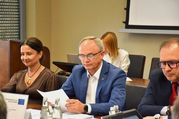 Członkowie Konwentu UJW przeglądają dokumenty przy stole.