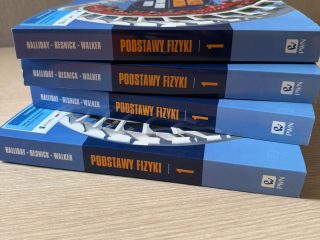 Stos podręczników „Podstawy fizyki” na stole.