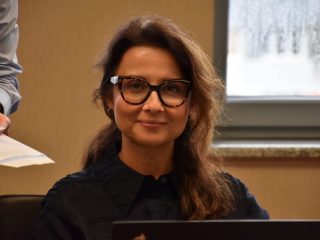 Uczestniczka posiedzenia Senatu UJW w okularach, siedząca za laptopem.