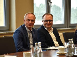 Dwaj uczestnicy posiedzenia Senatu UJW siedzący przy stole konferencyjnym.