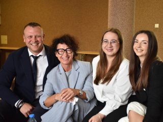 3 kobiety i 1 mężczyzna siedzą uśmiechnięci na kanapie w uczelni