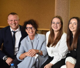 3 kobiety i 1 mężczyzna siedzą uśmiechnięci na kanapie w uczelni